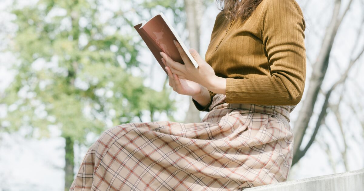 屋外で本を読む女性の横姿
