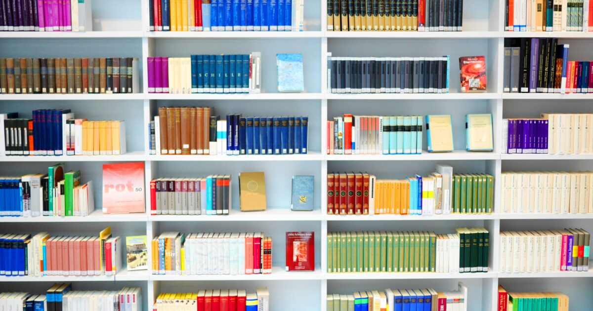 白い本棚に並ぶカラフルな本