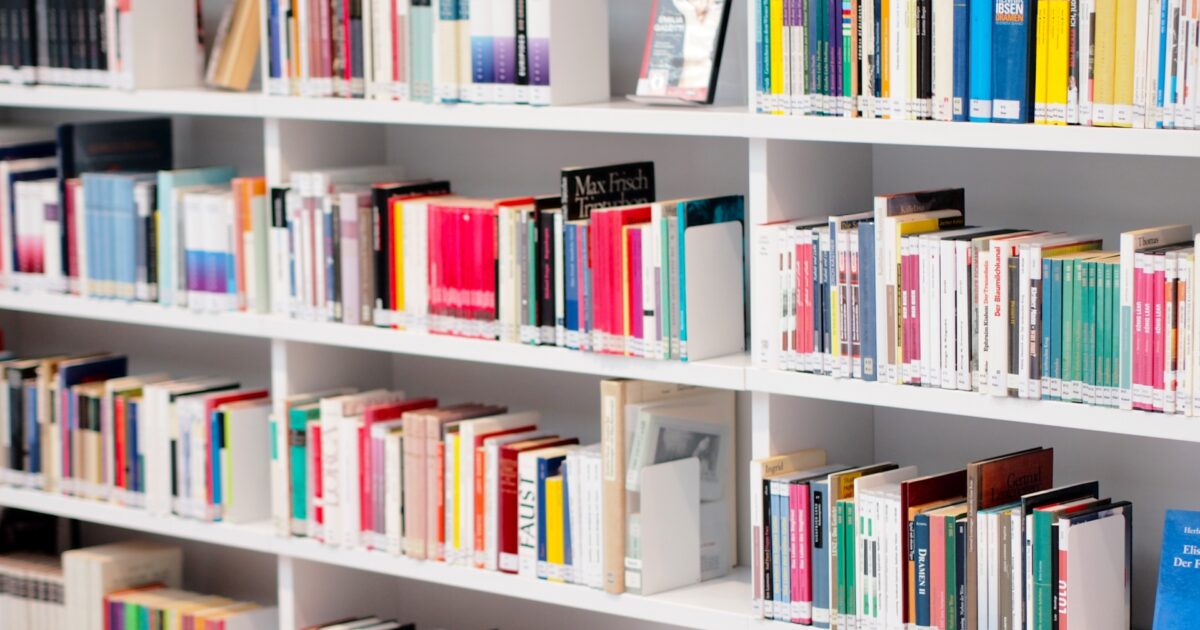 本が整然と並ぶ明るい図書館の棚