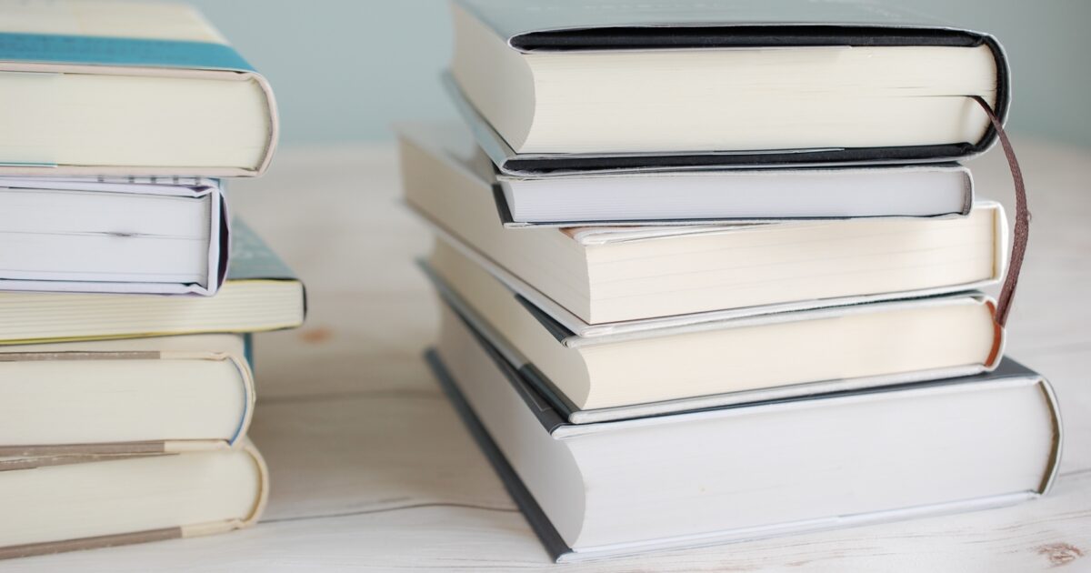 テーブルに積まれたハードカバーの本