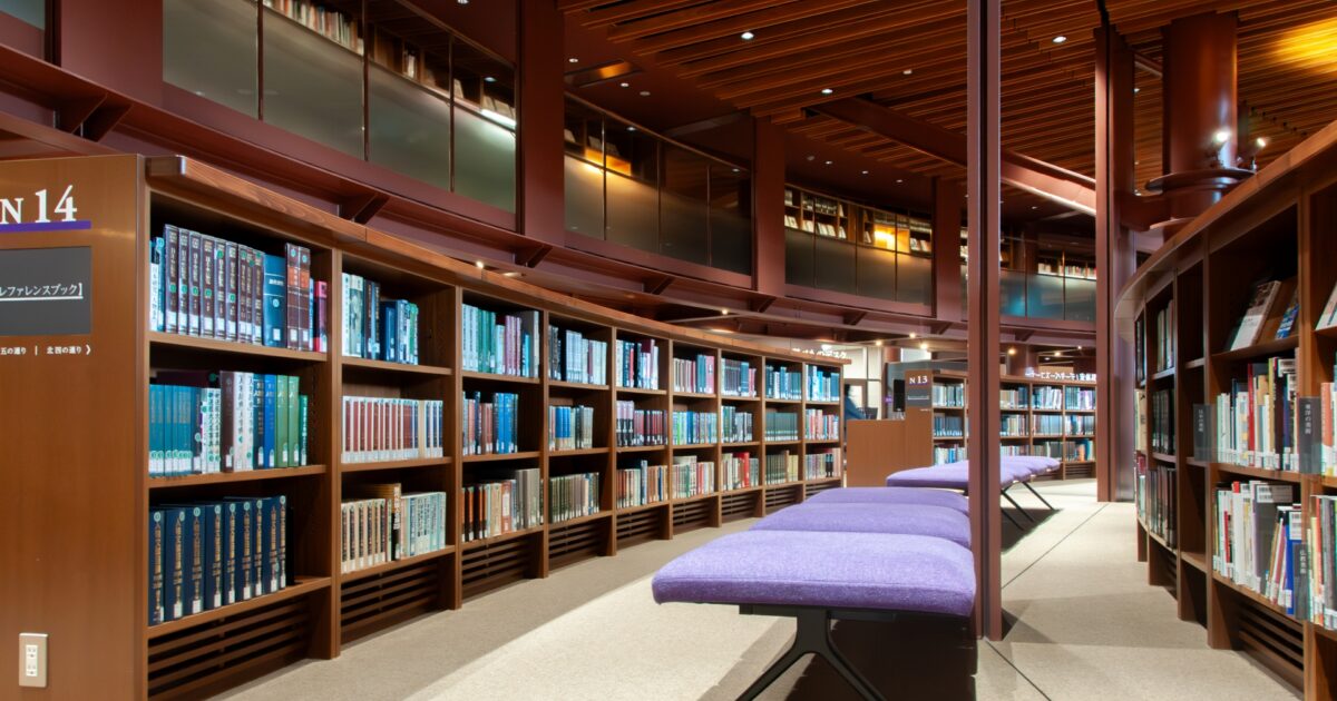 図書館の本棚と紫色のベンチのある空間